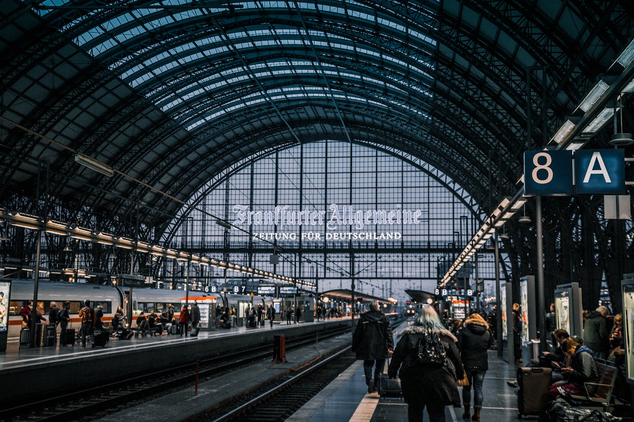 Interior view of Frankfurt Hauptbahnhof with trains and commuters.